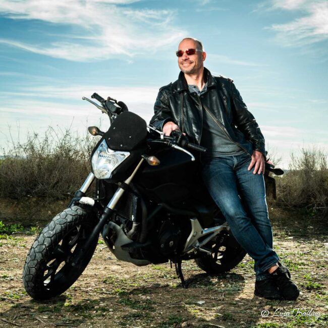 A man leaning to his motocycle